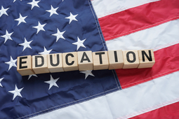 On the US flag lie a cubes with the inscription - EDUCATION LAWS AND GUIDANCE